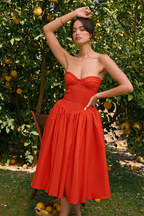 Robe midi rouge sans bretelles, corset et ourlet plissé, idéale pour les soirées de bal.