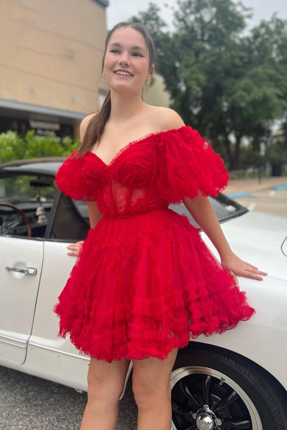 Robe de bal unique en tulle fuchsia, coupe trapèze, épaules dénudées et corset.