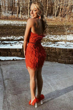 Robe fourreau rouge courte sans bretelles ornée de plumes, idéale pour un bal de promo.