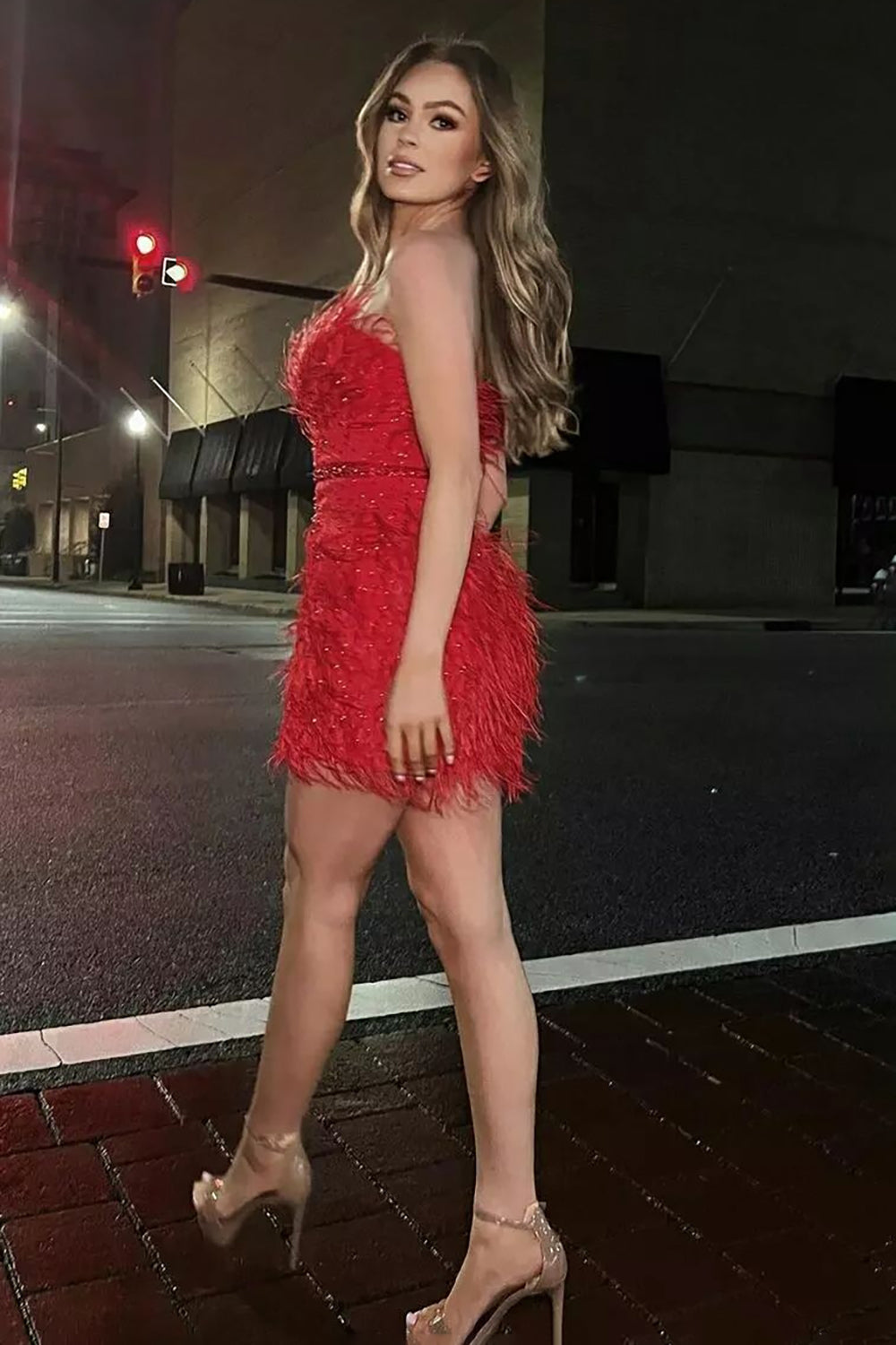 Robe fourreau rouge courte sans bretelles ornée de plumes, idéale pour un bal de promo.