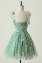 Robe de bal de promo champagne à fines bretelles et coupe trapèze, ornée de broderies.