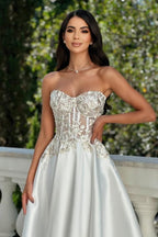 Impresionante vestido de graduación color marfil, corte en A, de satén, encaje, escote corazón y sin mangas, con apliques.