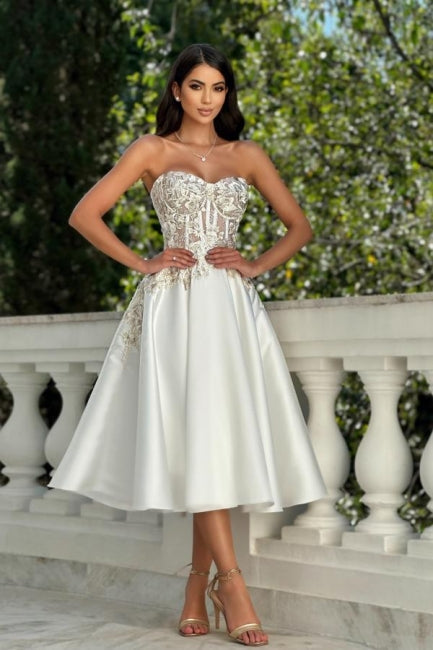 Impresionante vestido de graduación color marfil, corte en A, de satén, encaje, escote corazón y sin mangas, con apliques.