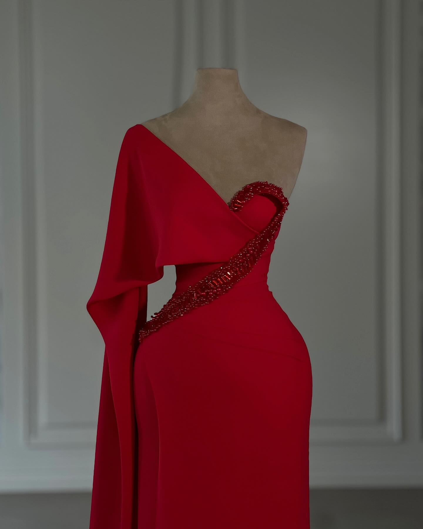 Impresionante vestido de fiesta rojo de gasa con un solo hombro y mangas cortas, adornado con pedrería.