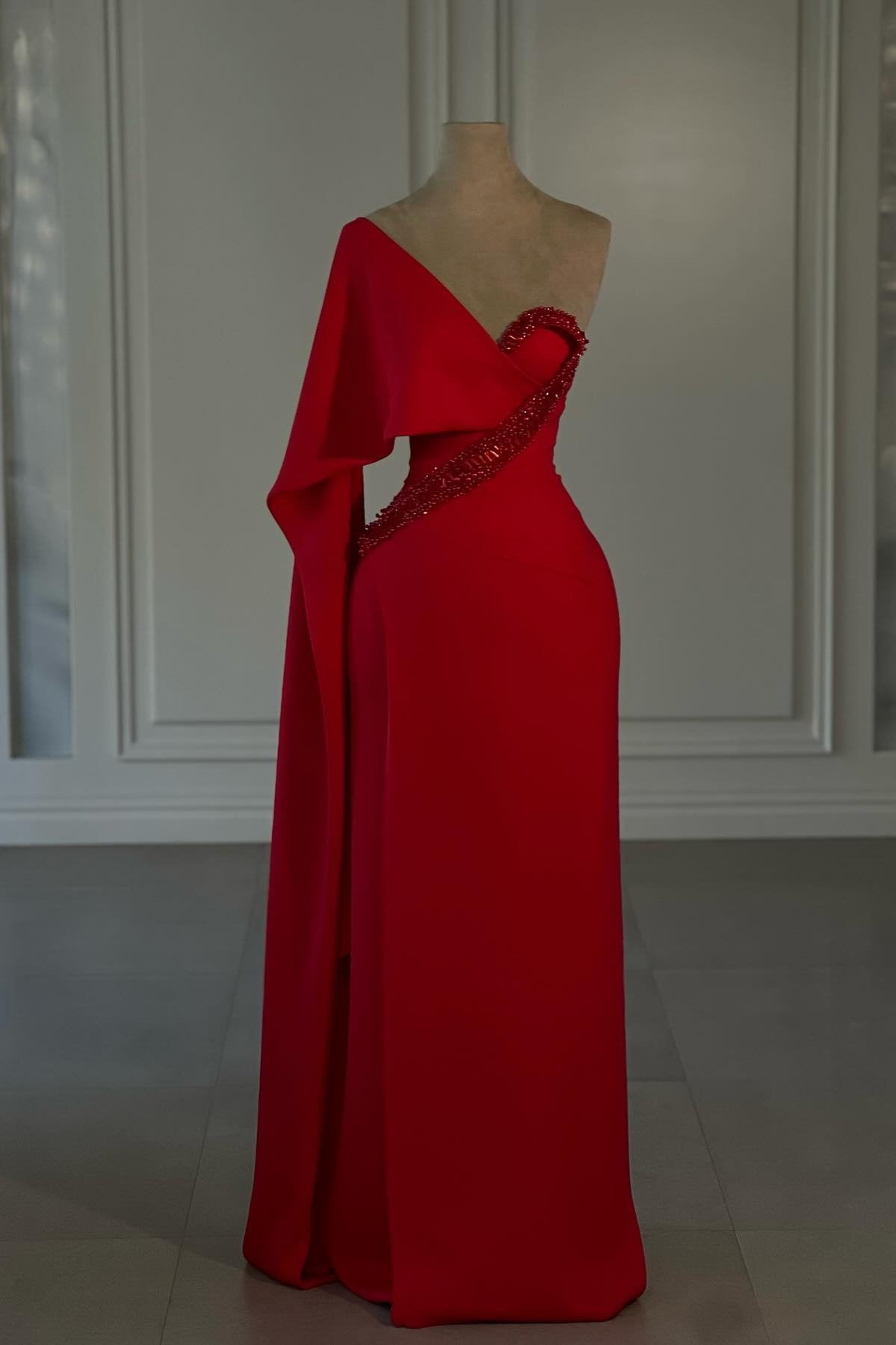 Impresionante vestido de fiesta rojo de gasa con un solo hombro y mangas cortas, adornado con pedrería.