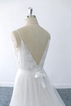 Magnifique robe de mariée longue en tulle à col V et volants appliqués, coupe trapèze, col en V.