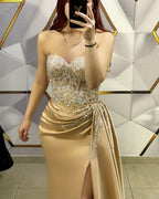 Impresionante vestido largo de fiesta color champán, sin mangas, con encaje, cuentas y abertura.