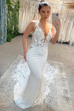 Impresionante vestido de novia largo blanco de corte sirena, sin mangas, con escote en V, tirantes finos y encaje.