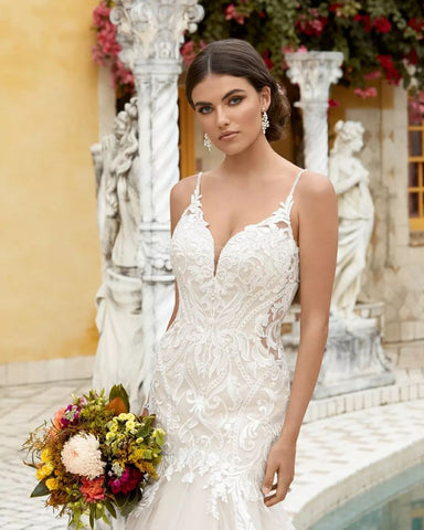 Magnifique robe de mariée blanche longue sans manches à fines bretelles spaghetti et volants, style sirène.