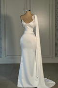 Impresionante vestido de novia blanco de sirena, de satén, sin mangas y con un solo hombro, adornado con pedrería.