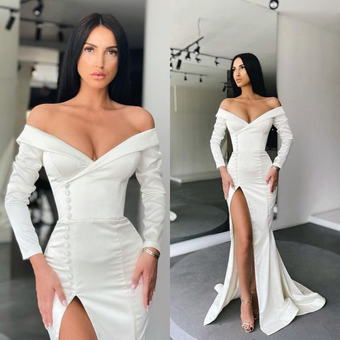 Impresionante vestido de noche blanco estilo sirena, con hombros descubiertos, abertura y mangas largas.
