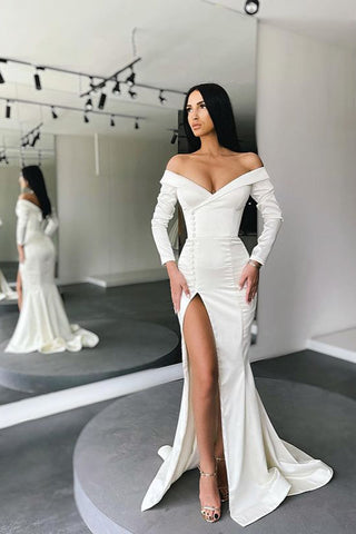 Impresionante vestido de noche blanco estilo sirena, con hombros descubiertos, abertura y mangas largas.