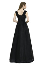 Atractivo vestido de fiesta negro de corte A con escote en V y apliques florales blancos de tul.