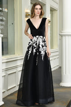Atractivo vestido de fiesta negro de corte A con escote en V y apliques florales blancos de tul.