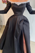 Atractivo vestido largo de fiesta negro de satén, corte en A, hombros descubiertos, abertura frontal, mangas largas y perlas.
