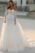 Robe de mariée blanche longue en dentelle, coupe trapèze, épaules dénudées et manches longues, ravissante.
