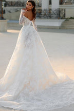 Robe de mariée blanche longue en dentelle, coupe trapèze, épaules dénudées et manches longues, ravissante.