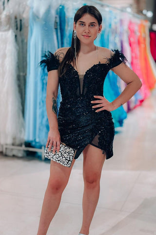 Robe de bal courte noire à paillettes et épaules dénudées, ornée de plumes, style fourreau glamour et scintillant.