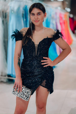 Robe de bal courte noire à paillettes et épaules dénudées, ornée de plumes, style fourreau glamour et scintillant.