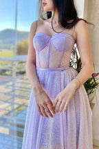 Vestido de fiesta lila con corsé, tirantes finos y corte en A, espalda cruzada.