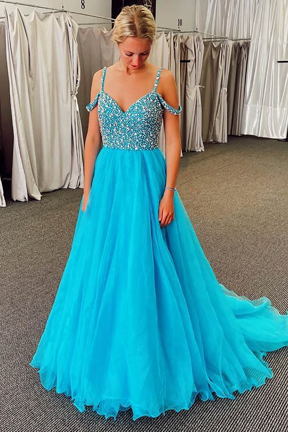 Vestido largo de fiesta azul con escote barco y detalles de pedrería.