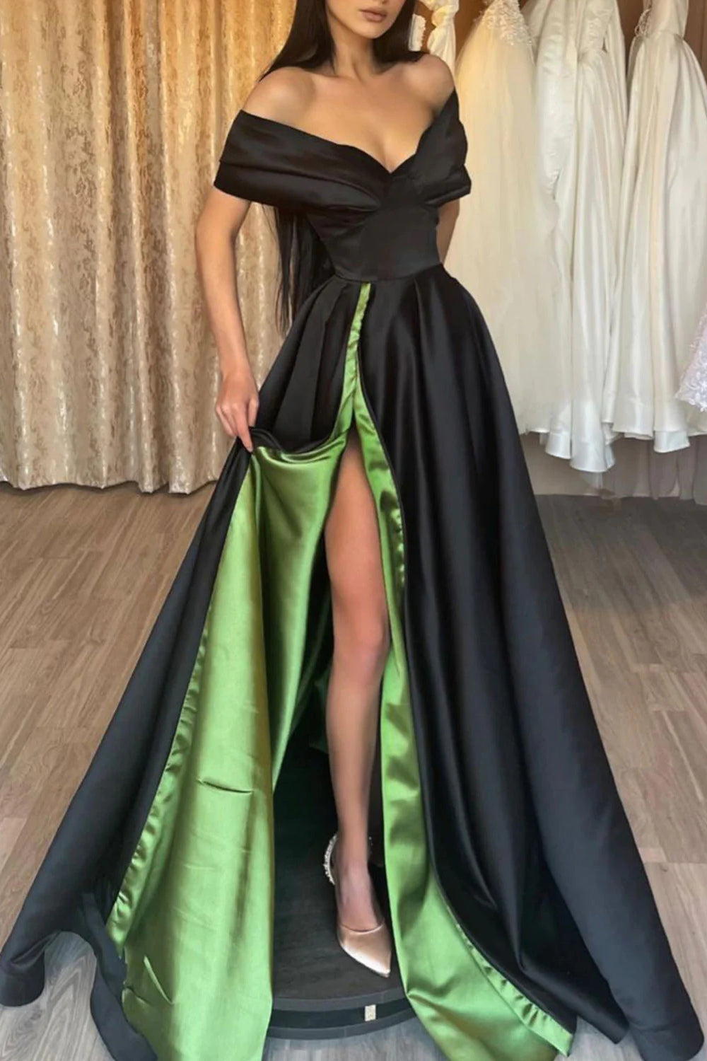 Vestido largo de fiesta negro y verde con escote barco y abertura frontal.