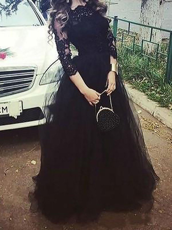 Vestido de gala de tul con encaje, manga tres cuartos y corte barco hasta el suelo.