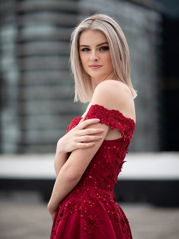 Vestido de gala largo hasta el suelo, sin mangas, con apliques de satén y hombros descubiertos.