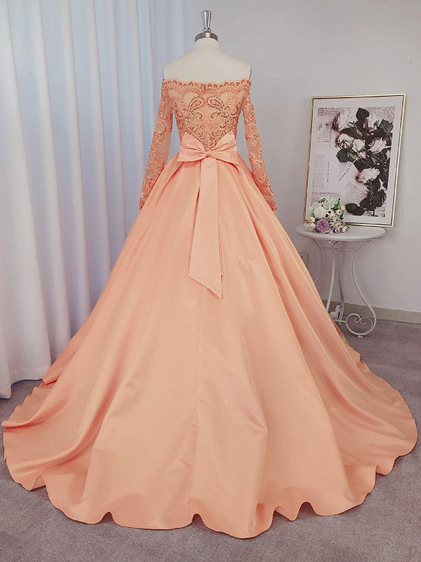 Vestido de gala de satén con mangas largas, bordado de cuentas, escote barco y cola de corte.