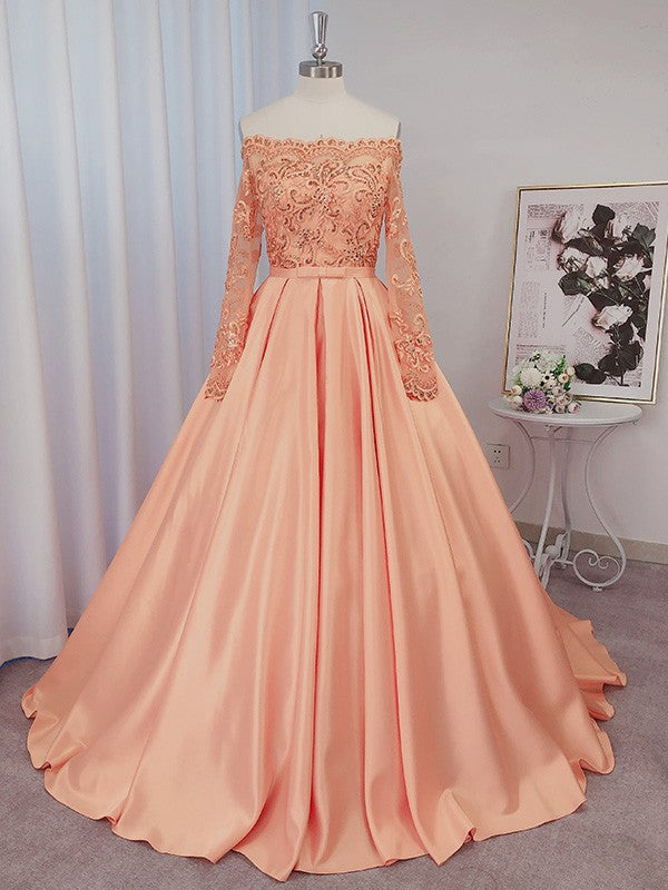 Vestido de gala de satén con mangas largas, bordado de cuentas, escote barco y cola de corte.