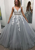 Robe de bal longue sans manches en tulle, arrivant au sol, ornée de dentelle et de perles appliquées.
