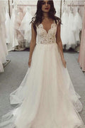 Robe de mariée longue en tulle et dentelle couleur ivoire, coupe trapèze, col en V, couleur plage