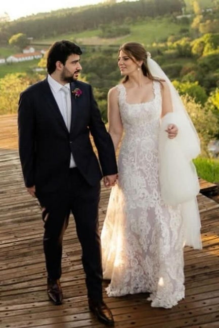 Magnifique robe de mariée longue ivoire en dentelle, coupe trapèze, sans manches, ornée d'appliqués.