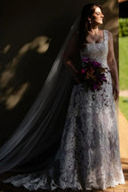 Magnifique robe de mariée longue ivoire en dentelle, coupe trapèze, sans manches, ornée d'appliqués.