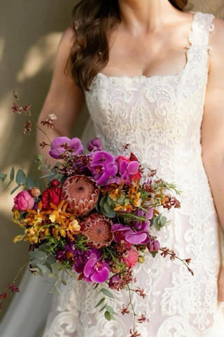 Magnifique robe de mariée longue ivoire en dentelle, coupe trapèze, sans manches, ornée d'appliqués.