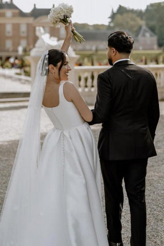 Precioso vestido de novia blanco de satén, corte en A, sin mangas, con hombros descubiertos y abertura frontal.
