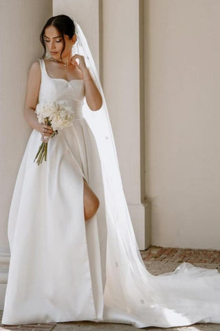 Precioso vestido de novia blanco de satén, corte en A, sin mangas, con hombros descubiertos y abertura frontal.