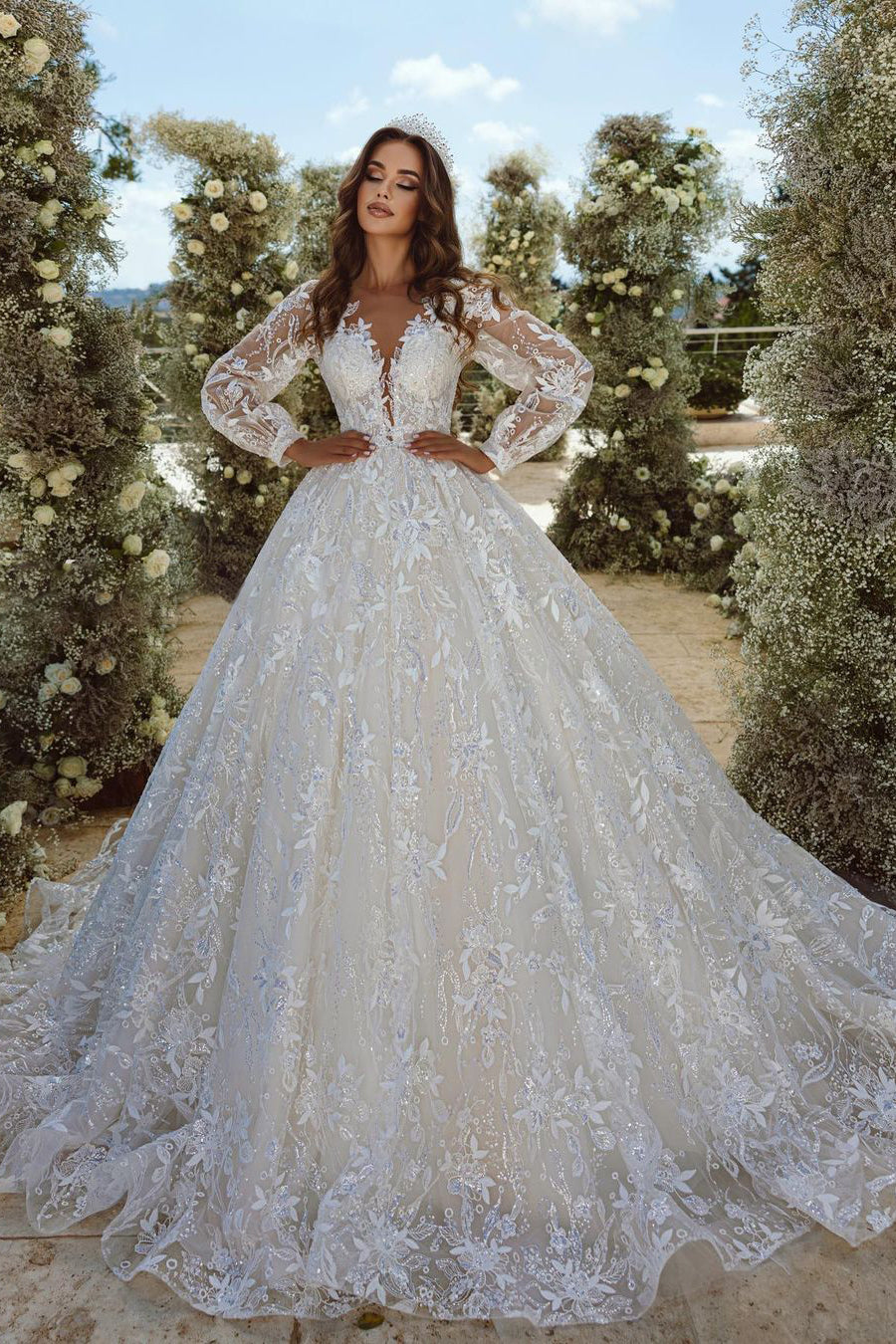 Magnifique robe de mariée en tulle à manches longues, coupe trapèze, col en V et applications de dentelle.