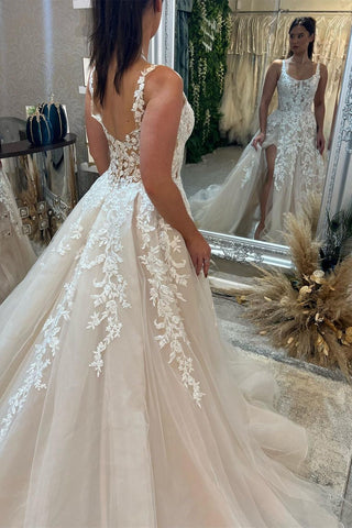 Magnifique robe de mariée longue sans manches à bretelles, coupe trapèze, en dentelle et fente.