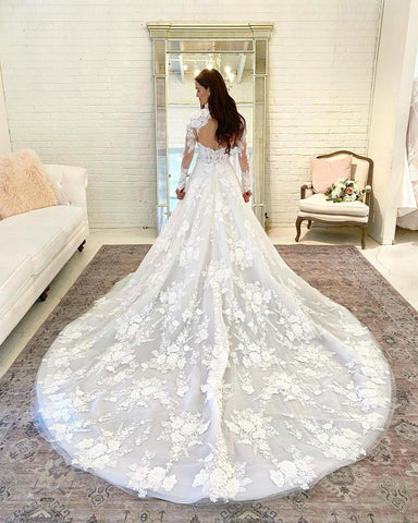 Precioso vestido de novia largo de corte A, cuello alto, espalda descubierta de encaje y mangas.