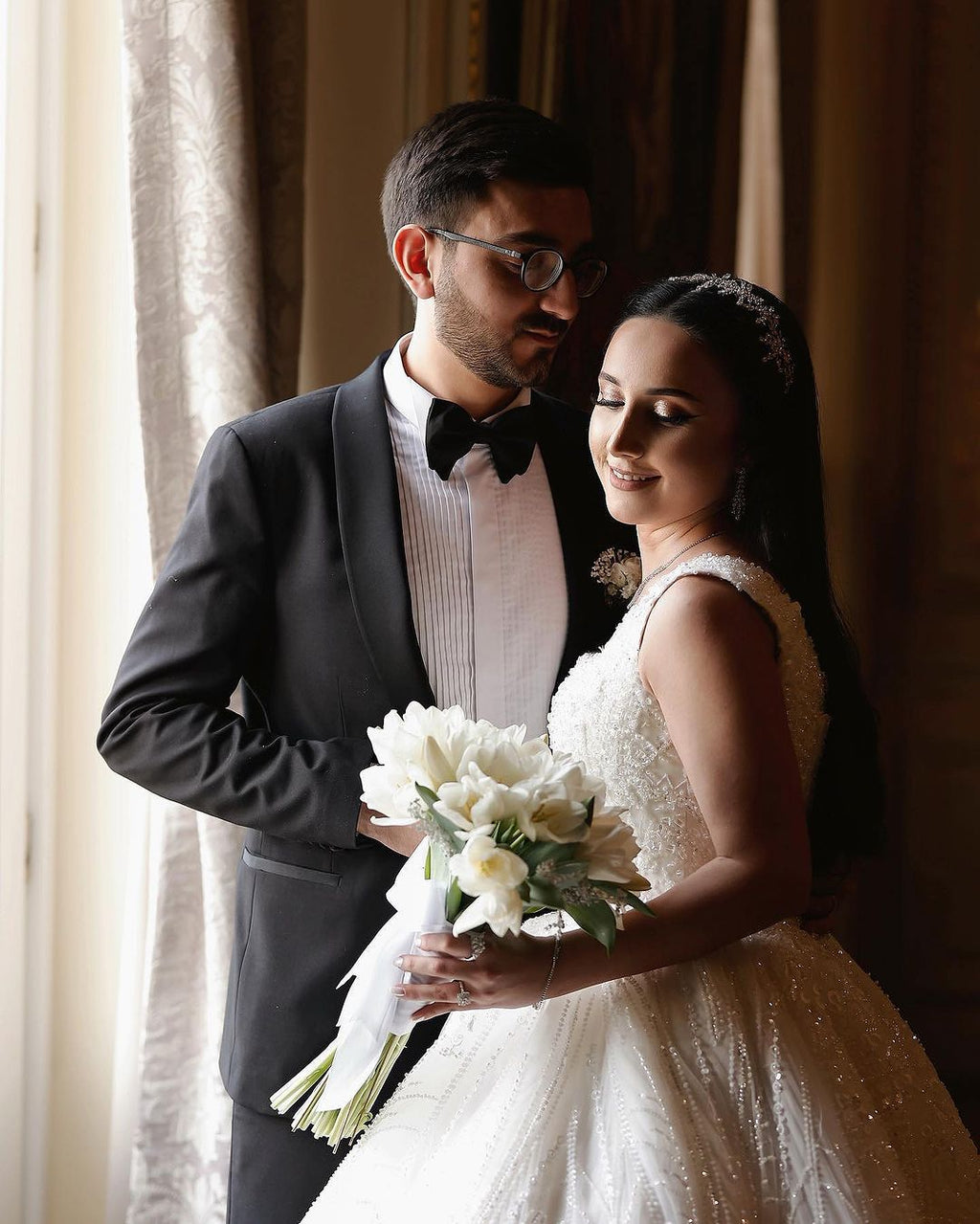 Magnifique robe de mariée longue ivoire, coupe trapèze, sans manches, ornée de perles et de dentelle.