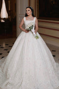 Magnifique robe de mariée longue ivoire, coupe trapèze, sans manches, ornée de perles et de dentelle.