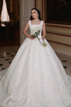 Magnifique robe de mariée longue ivoire, coupe trapèze, sans manches, ornée de perles et de dentelle.