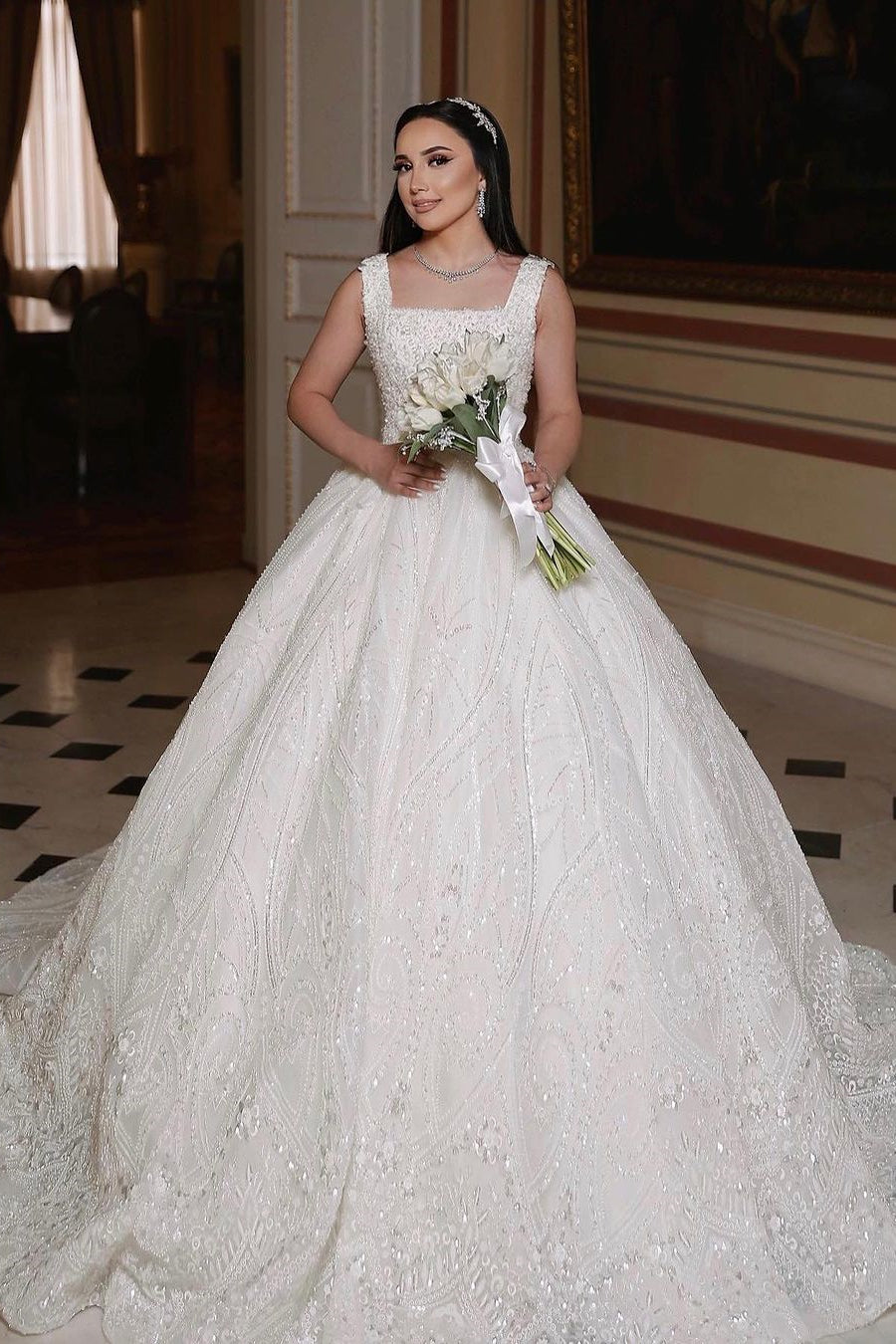 Magnifique robe de mariée longue ivoire, coupe trapèze, sans manches, ornée de perles et de dentelle.