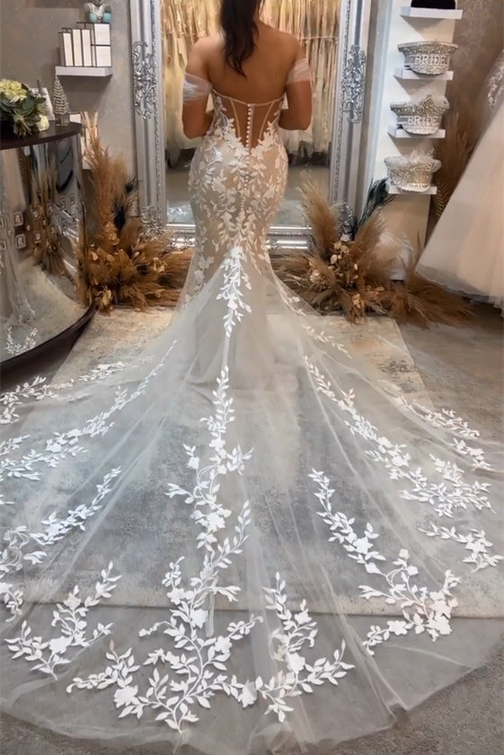 Magnifique robe de mariée sirène longue sans manches, épaules dénudées, ornée d'appliqués et de dentelle.