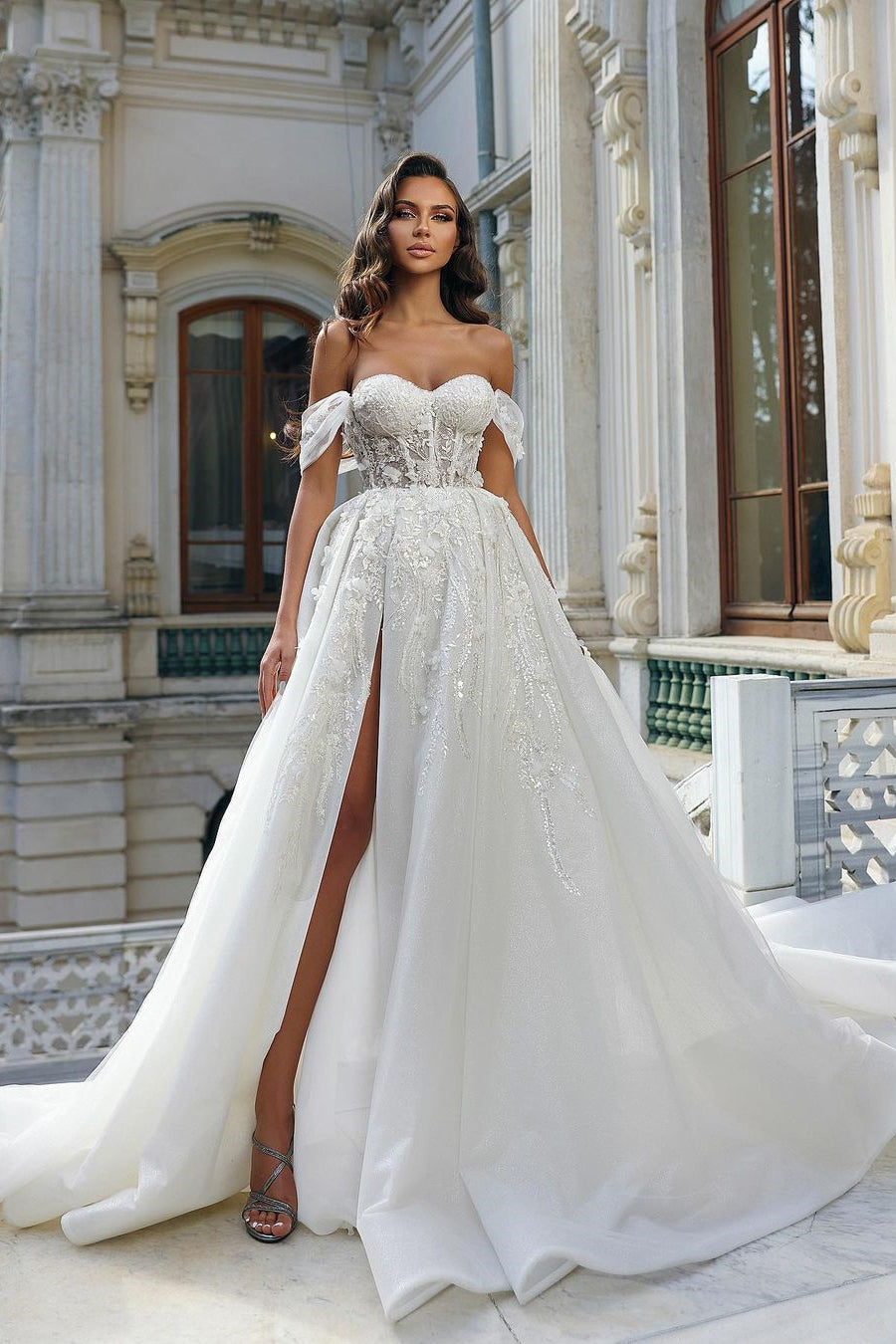 Magnifique robe de mariée blanche longue en dentelle à fleurs, coupe trapèze, épaules dénudées et fente.