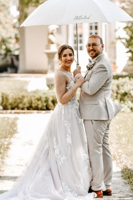 Magnifique robe de mariée blanche longue, coupe trapèze, col en V, sans manches, ornée de dentelle.