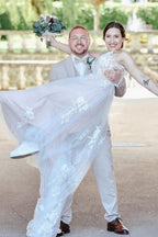 Magnifique robe de mariée blanche longue, coupe trapèze, col en V, sans manches, ornée de dentelle.
