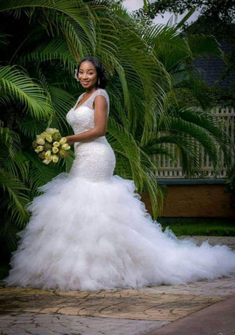 Precioso vestido de novia de sirena con escote en V, sin mangas y con pedrería.