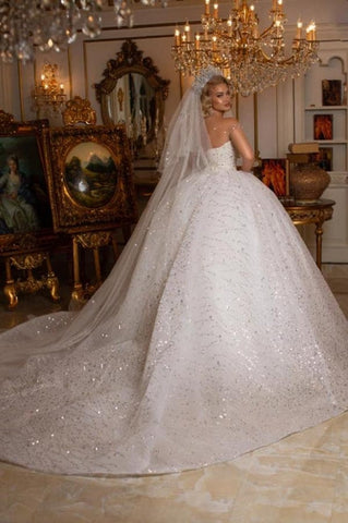 Precioso vestido de novia de corte princesa, sin mangas, con escote corazón y hombros descubiertos, con purpurina.